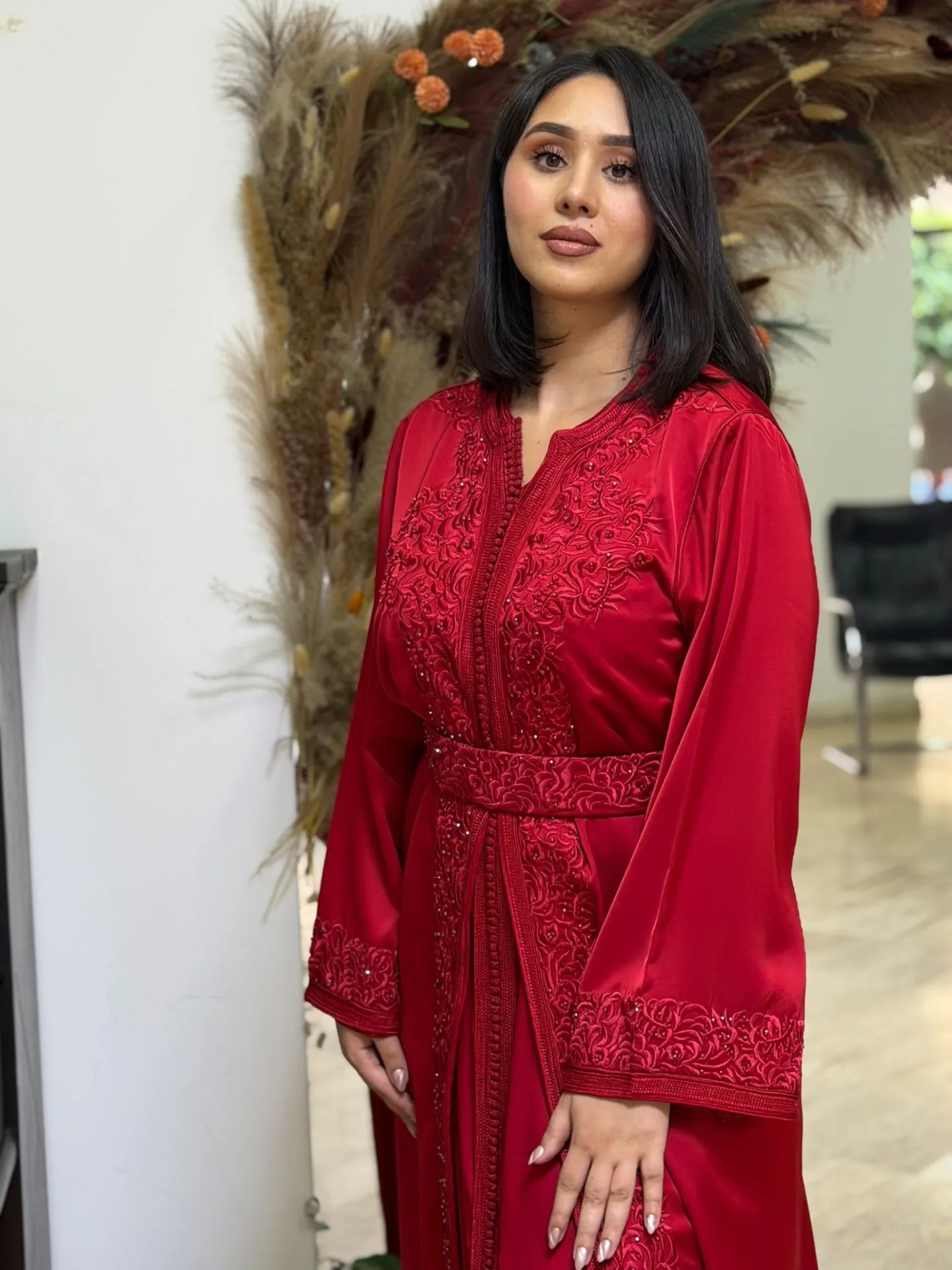 Détail de la broderie florale d'un caftan rouge grenat en satin