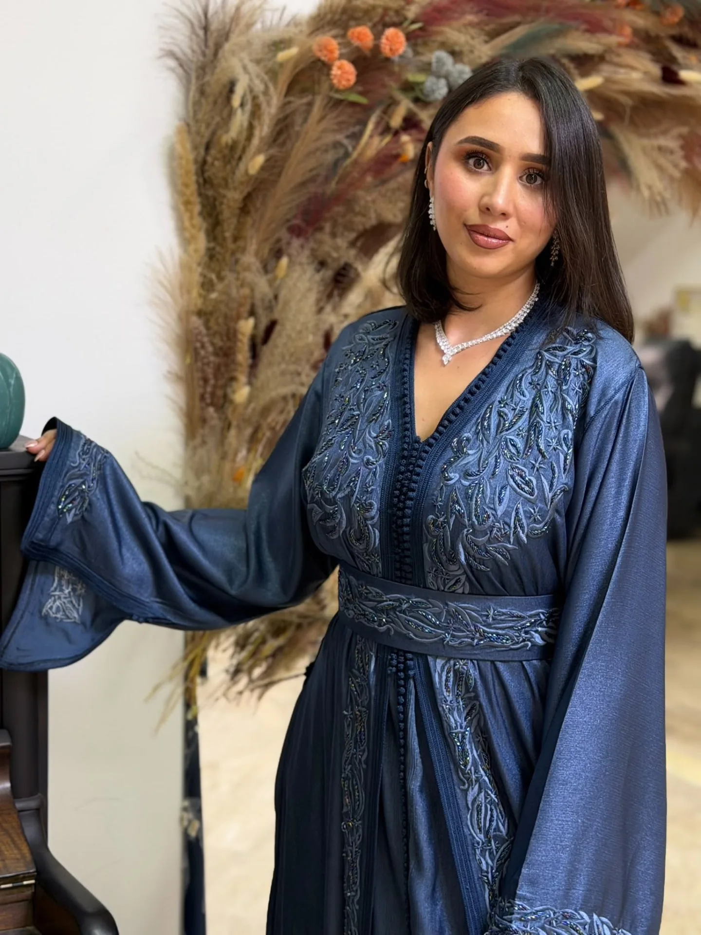 Détail du buste d'un caftan bleu ardoise brodé de motifs floraux perlés